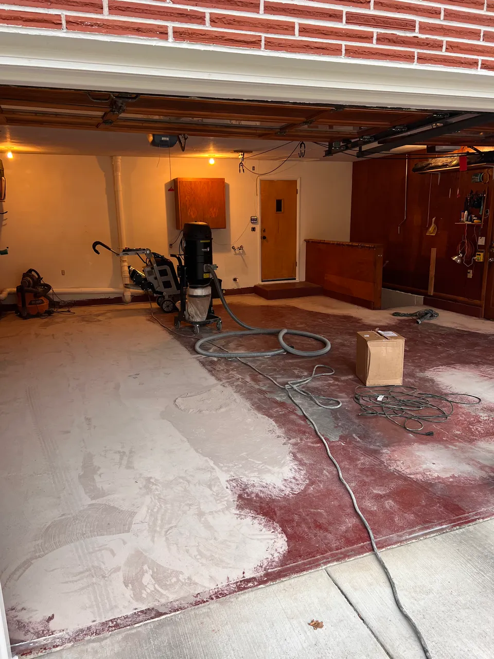 Concrete grinding equipment and surface preparation in a garage before coating