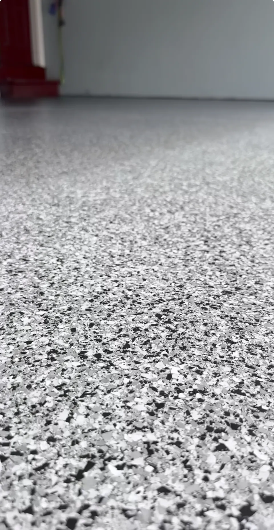 Close view of a gray, white, and black flake garage floor